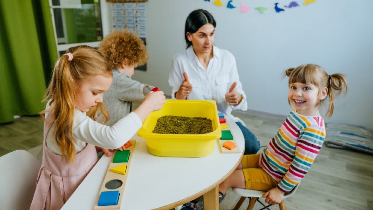 Preschool students playing with beans in kindergarten