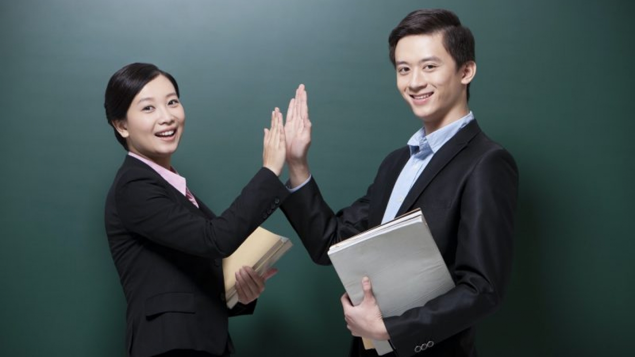 Professional male teacher and female teacher doing high-five